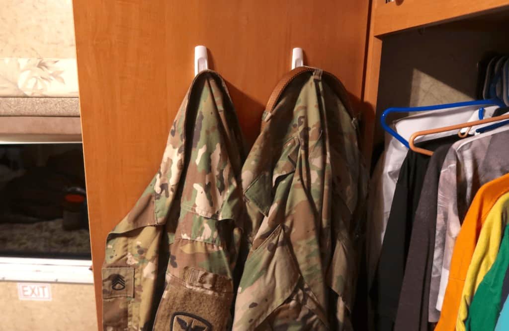 command hooks hanging up military clothes on back of rv door to organize it better